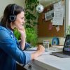 Female teacher in headphones teaching young student girl online.