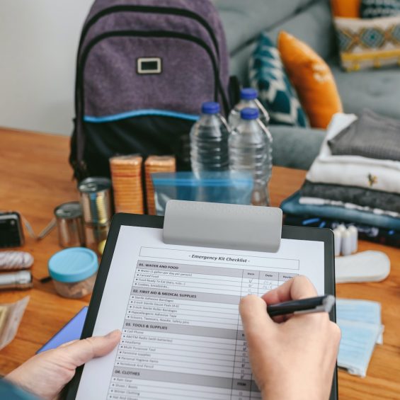 Woman doing checklist of emergency backpack